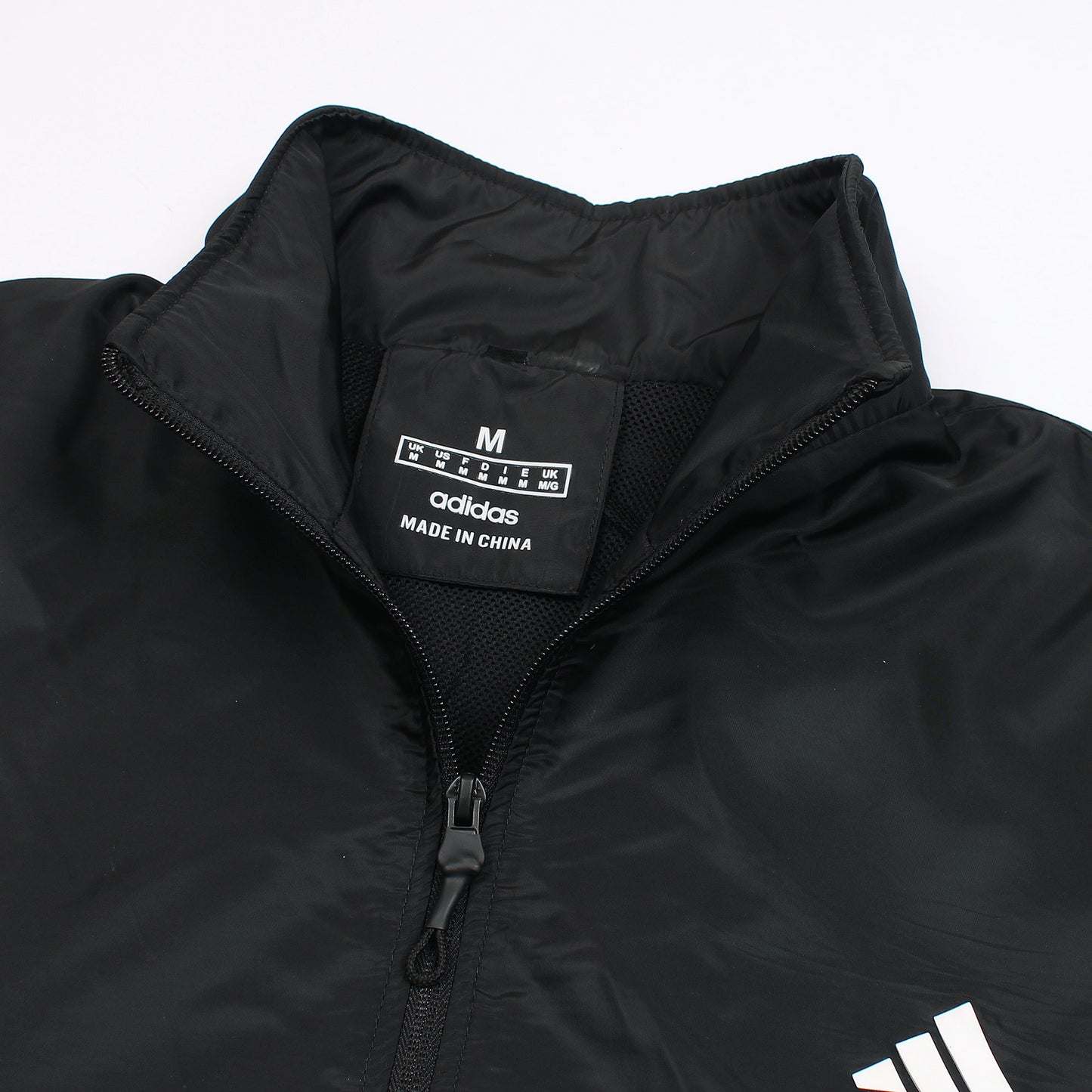 Black jacket with Adidas logo and text on a white background